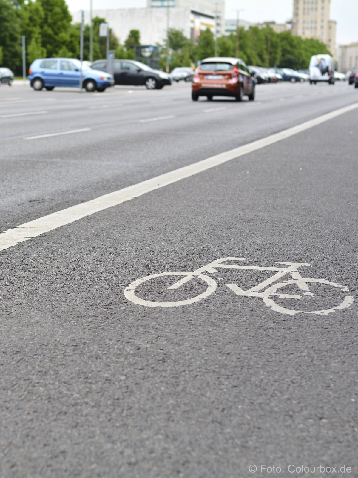 Bild zeigt eine Straße mit Auto sowie Radweg